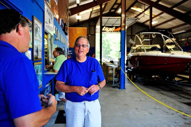 Customer John Anderson speaks with owner Travis Hayes (left) while picking up his Scout boat that was repaired at Hayes Marine in Appling.