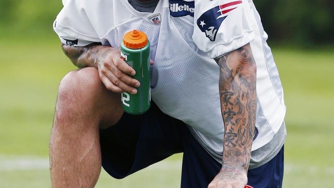 New England Patriots' Aaron Hernandez kneels on the field during NFL football practice in Foxborough, Mass., Wednesday, May 29, 2013. (AP Photo/Michael Dwyer)