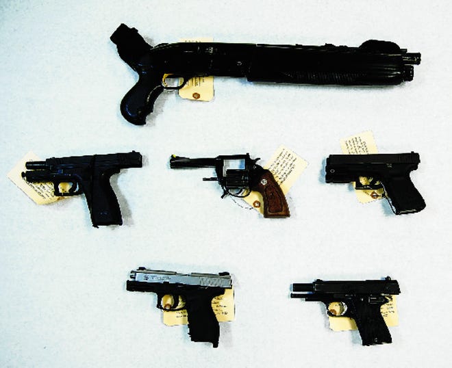 Six of the seven guns seized Thursday from a home in the 1900 block of East 9th Street. Charlie Lo, 26, was arrested on weapons and other charges.