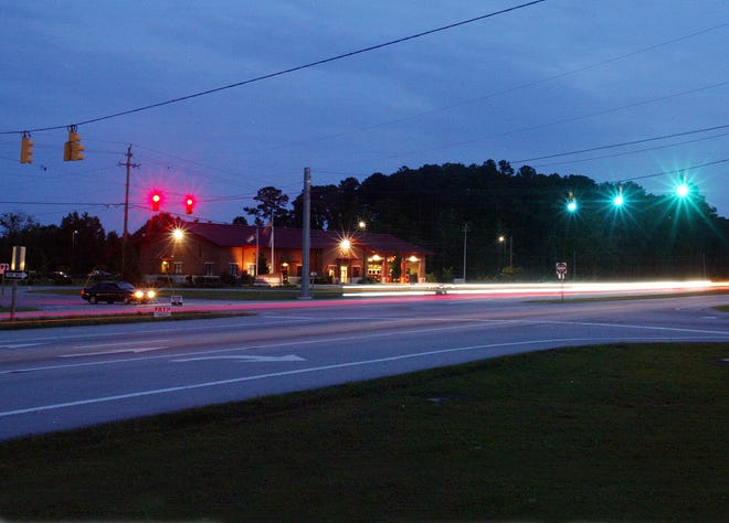 A driver waits as traffic streaks at the traffic light at U.S. 70 and the entrance to Tucker Creek.