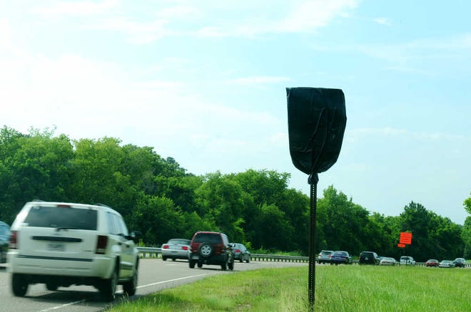 A black bag covers a 45 mph speed limit sign on River Watch Parkway.