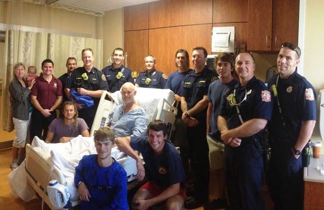 First responders visit T.C. Carr at Flagler Hospital on June 18, 2013. From left to right (baby not identified): Back Row: Eileen Carr, Jered Solana, Eric Jones, Robert Herring, Steve Uzelac, Brian Miller, Jeremy Watkins, Daniel Power, Josh Clingerman, Mike Riley and Dustin Hamilton. Front Row: Casey Carr, T.C. Carr, Dylan Carr and Derek Droege. Contributed photo.