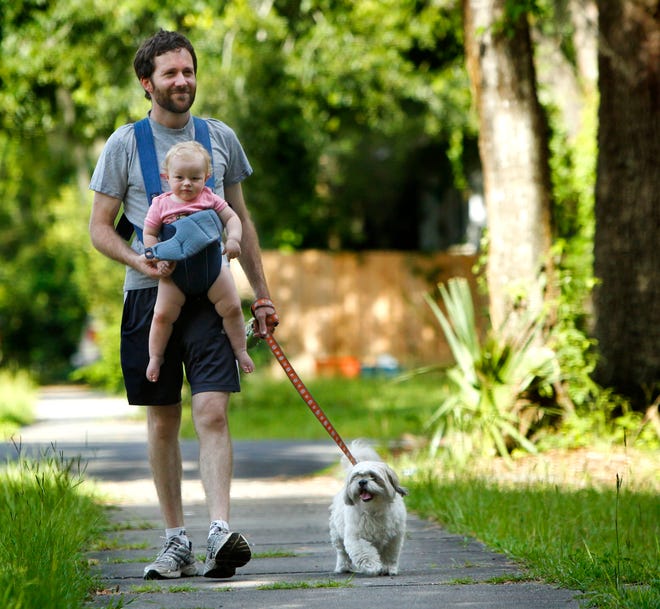Michel Volk strolls with his daughter Elsa Violet Laughlin-Volk, 11 months, down NE 3rd Ave. as they walk their dog Mollie, in Gainesville, Sunday June 23, 2013.