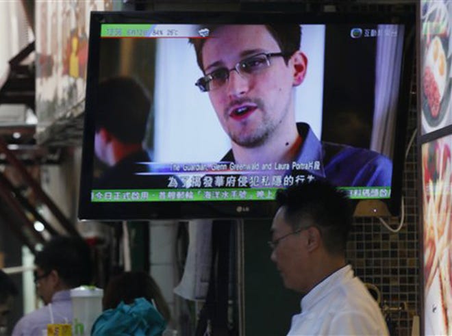 A TV screen shows the news of Edward Snowden, former CIA employee who leaked top-secret documents about sweeping U.S. surveillance programs, at a restaurant in Hong Kong Wednesday, June 12, 2013. The whereabouts of Snowden remained unknown Wednesday, two days after he checked out of a Hong Kong hotel.