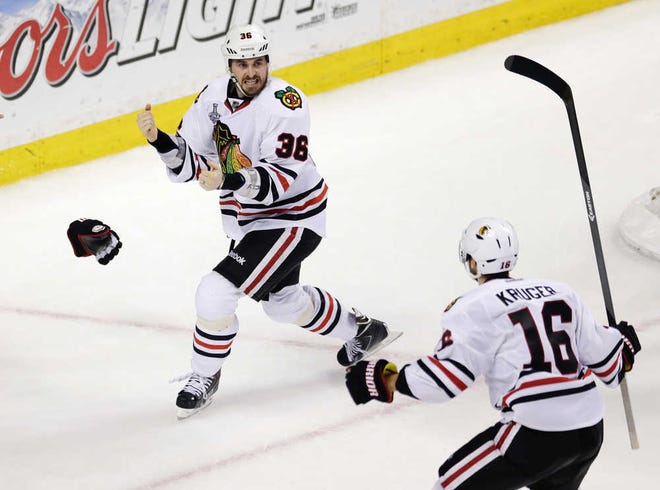 Chicago's Dave Bolland (left) celebrates his goal with Marcus Kruger late in the third period. The Blackhawks clinched the title for the second time in four seasons.