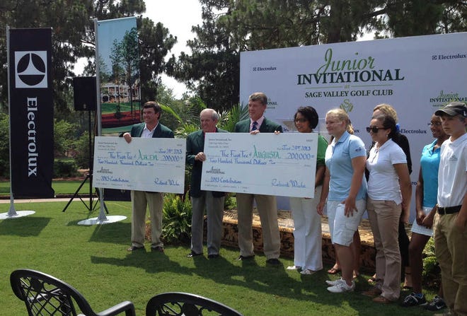 Tournament chairman Tom Wyatt (from left), Sage Valley founder Weldon Wyatt and Mark Chambers of Electrolux present $200,000 checks to members of the First Tee chapters in both Augusta and Aiken.