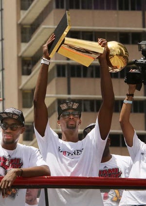 Jose A. Iglesias Miami Herald  Chris Bosh holds the championship trophy as the team celebrates its second consecutive title with a parade on Monday in Miami.