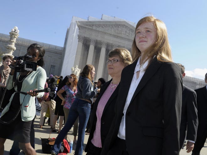 Abigail Fisher, right, who sued the University of Texas, walks outside the Supreme Court on Oct. 10, 2012, in Washington. The Supreme Court has sent a Texas case on race-based college admissions back to a lower court for another look. The court's 7-1 decision Monday leaves unsettled many of the basic questions about the continued use of race as a factor in college admissions.