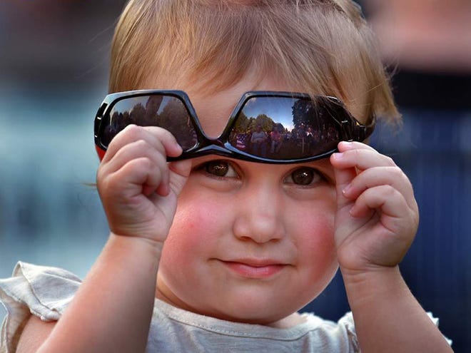 Sophia Jorgensen, 2, of Spartanburg, peeks under sunglasses as she and her family enjoy the Stroller Summer Jam, held at Boiling Springs Community Park in Boiling Springs, Saturday evening, 6-22-2013. The 4th-annual event was a fundraiser for Mobile Meals of Spartanburg.