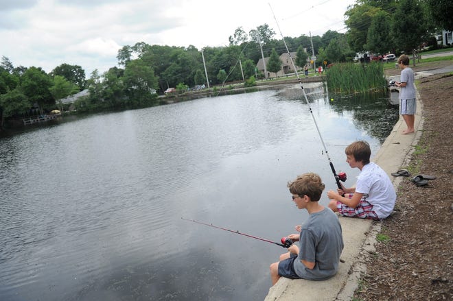 William Johnson, 12, left, Ryan Bettencourt, 13, and Andrew Johnson, 10, all of Bridgewater, try to catch their first fish of the day in Johnson's Pond in Raynham on Monday, July 29, 2013.