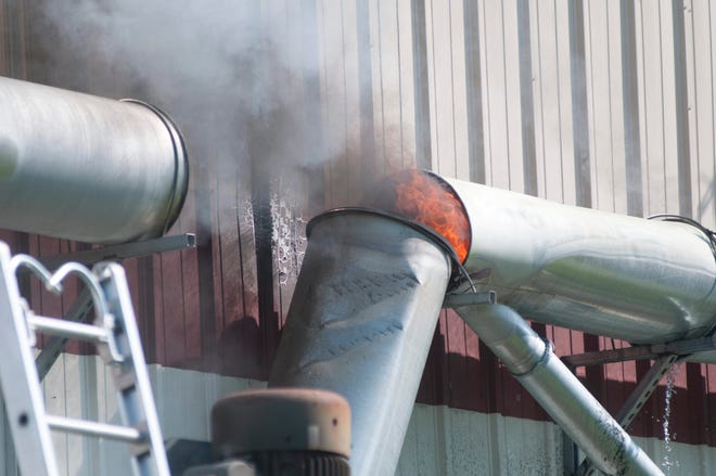 A fire is seen here in a venting system at Roll Service Industries in Dover Monday afternoon.