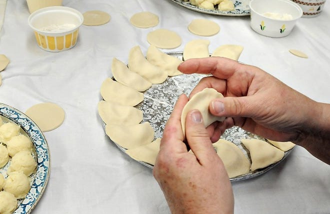 Joan Kravchak pinches a potato and cheese pierogie at Saint Mary Catholic Church in Bristol Township. Parishioners have been making and selling pierogies for over 50 years as a fundraiser for the church.