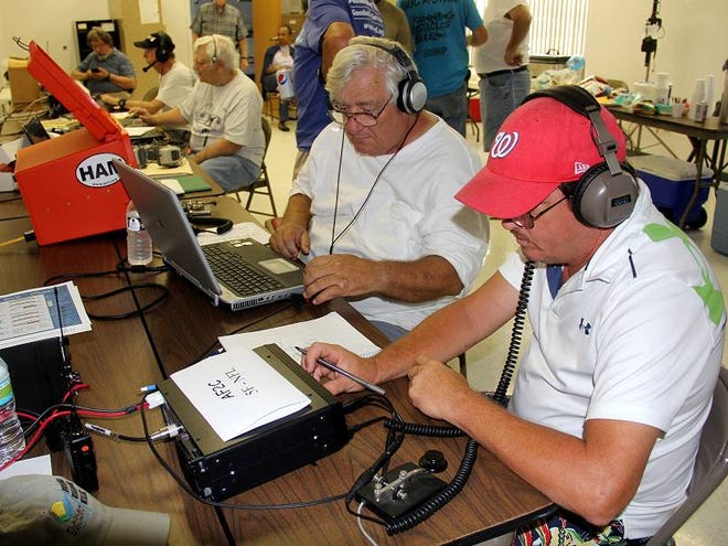 Pat Eckenrode, right, attempts to contact a ham operator in North Carolina as David Snow logs contacts on the computer during the ARRL National Field Day by the Flagler Emergency Communications Association at the Flagler Beach Fire Station.