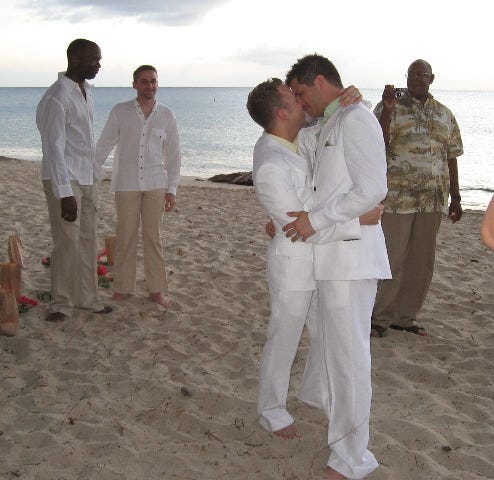U.S. Army Maj. Alan G. Rogers (far left) holds hands with his partner during a same-sex wedding ceremony in June 2006. Rogers was an ordained pastor and died in 2008. His death was the first known gay combat fatality of Operation Iraqi Freedom.