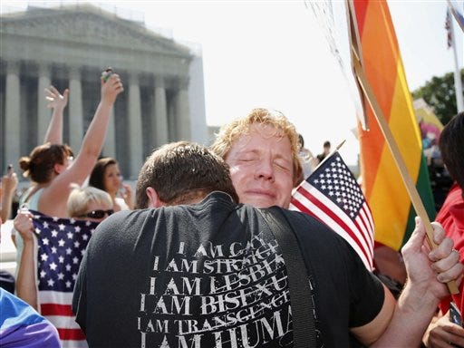 Michael Knaapen, left, and his husband John Becker, right, embrace outside the Supreme Court in Washington after the court struck down a federal provision denying benefits to legally married gay couples.