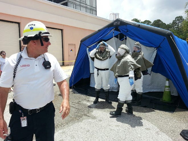Florida Hospital Flagler decontamination team members dress in the required personal protective equipment prior to entering the decontamination tent.