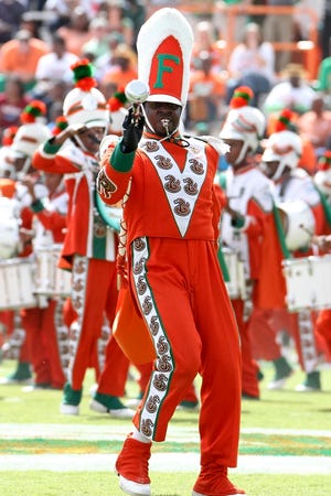 FILE - In this Oct. 8, 2011 file photo, Florida A&M Marching 100 Drum Major Robert Champion performs during a performance at halftime of the game against Howard University at Bragg Memorial Stadium in Tallahassee, Fla. Champion, 26, died in Orlando in November 2011 after he collapsed following what prosecutors say was a savage beating during a hazing ritual. Florida A&M University's interim president said Thursday, June 27, 2013 that he was lifting the suspension of its famous Marching 100 band about a year and a half after Champion's death that led to the departure of school leaders and reforms trying to crack down on brutal hazing in the band. (AP Photo/Don Juan Moore, File)