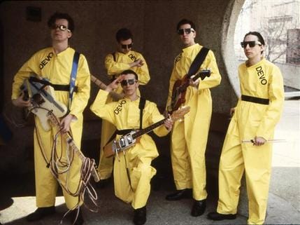 In this 1978 photo taken by Janet Macoska and released by Devo, Inc., the band Devo, from left, Mark Mothersbaugh, Bob Mothersbaugh, kneeling, Jerry Casale, Bob Casale and Alan Myers pose for a photo.