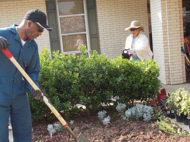 Donaldsonville City Councilman Lauthaught Delaney, Sr. and volunteer Robyn Penn Delaney work to clean the flower garden at the City Hall.