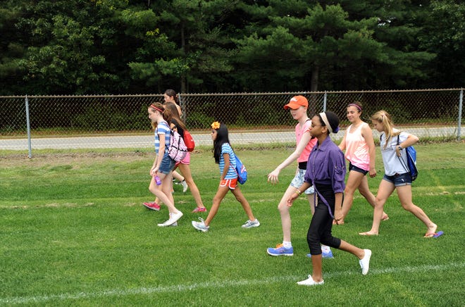 Shannon Curley (middle/orange hat) walks with her classmates during Wednesday morning's Walk-A-Thon fundraiser at Concord Middle School's Sanborn building. Curley was diagnosed with leukemia in December 2012 and has had successful chemotherapy treatments, as well as a bone marrow transplant. The 6th graders raised more than $5,000 for Children's Hospital in Boston. Wicked Local Photo/James Jesson
