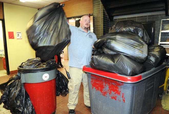 Custodian P.J. Pentz collects trash bags in the Red Cafeteria during lunch period at Brockton High School.