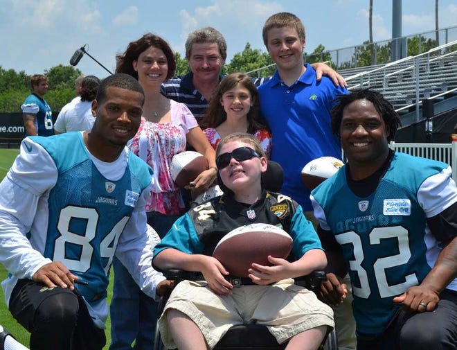Daniel Thompson, named "Jaguar for a Day," has his photo taken with Jaguars receiver Cecil Shorts (84) and running back Maurice Jones-Drew. Joining Daniel were his mother Dawn (from left), father Fred, sister Rachel and brother Corey. Provided by Kipin Alexander