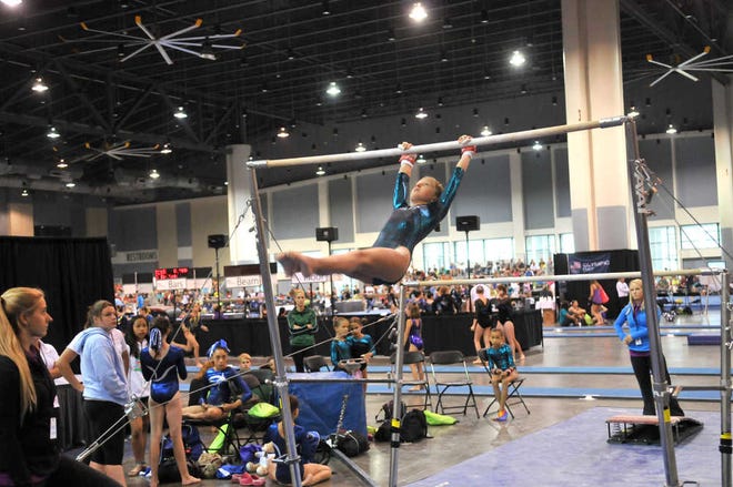 Richard Burkhart/Savannah Morning News Sydney Orr, from the Islands YMCA, completes her routine on the uneven bars during the 2013 YMCA Gymnastics Championship Friday at the Savannah International Trade and Convention Center.