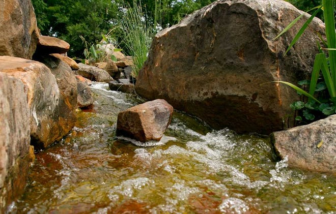The new water feature at the Kansas Children's Discovery Center has a stream which flows through sever small bolders while making its way to the pond at the bottom.