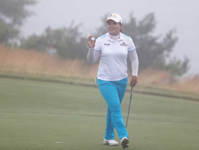 Inbee Park, from South Korea, acknowledges the crowd after sinking a putt on the 18th hole during the second round at the U.S. Women's Open golf tournament at Sebonack Golf Club in Southampton, N.Y., Friday, June 28, 2013. Play was eventually suspended due to heavy fog. (AP Photo/Seth Wenig)
