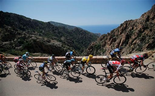 The pack with Jan Bakelants of Belgium, wearing the overall leader's yellow jersey, passes rock formations near Piana during the third stage of the Tour de France cycling race over 145.5 kilometers (91 miles) with start in Ajaccio and finish in Calvi, Corsica island, France, Monday July 1, 2013.