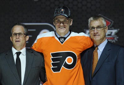 Samuel Morin , a defenseman, stands with officials from the Philadelphia Flyers sweater after being chosen 11th overall in the first round of the NHL hockey draft, Sunday, June 30, 2013, in Newark, N.J. (AP Photo/Bill Kostroun)