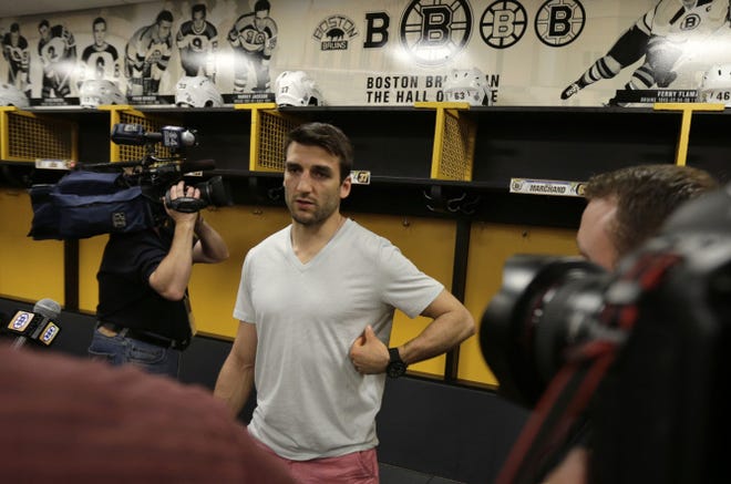 Bruins center Patrice Bergeron gestures towards a broken rib on his left side that he suffered during the Stanley Cup finals and eventually led to a punctured lung.