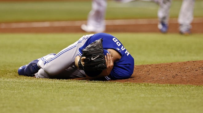 Toronto Blue Jays starting pitcher J.A. Happ reacts after being hit in the head with a line drive off the bat of Tampa Bay Rays' Desmond Jennings during the second inning of a baseball game Tuesday, May 7, 2013, in St. Petersburg, Fla. (AP Photo/Mike Carlson)
