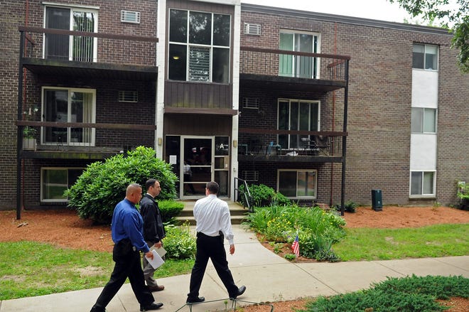 State and North Attleboro police walk past the Ledgewood Condominium Complex building in Franklin where Aaron Hernandez was seen. Unit A-12 is on the top floor at right.