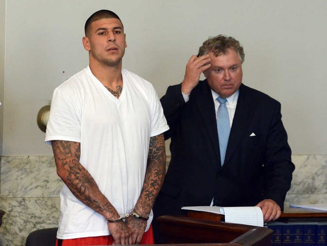 Former New England Patriots tight end Aaron Hernandez, left, stands with his attorney Michael Fee during arraignment in Attleboro District Court on June 26.