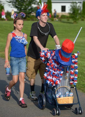 Jeremy Tickle and Brianna Nelson sell 4th of July paraphernalia at Northeast Park in Gibsonville Wednesday evening during the park's Fireworks Extravaganza.