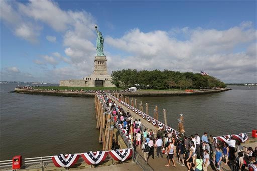 Visitors to the Statue of Liberty disembark onto Liberty Island from the first ferry to leave Manhattan, Thursday, July 4, 2013, in New York. The Statue of Liberty finally reopened on the Fourth of July months after Superstorm Sandy swamped its little island in New York Harbor as Americans across the country marked the holiday with fireworks and barbecues. (AP Photo/Mary Altaffer)