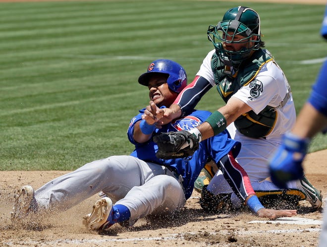 Oakland catcher Derek Norris tags out the Chicago Cubs' Starlin Castro, who tried to score on Alfonso Soriano's fourth-inning single in the Athletics' 1-0 victory Thursday. (MARCIO JOSE SANCHEZ/AP)
