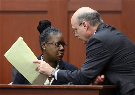 Assistant state attorney Bernie de la Rionda, right, talks to Sybrina Fulton, Trayvon Martin's mother, on the stand during a recess in George Zimmerman's trial in Seminole circuit court, Friday, July 5, 2013 in Sanford, Fla. Zimmerman has been charged with second-degree murder for the 2012 shooting death of Trayvon Martin. (AP Photo/Orlando Sentinel, Gary W. Green, Pool)