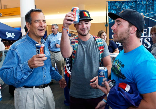 Passengers try Boston Lager in cans with Jim Koch of Samuel Adams, left, at the JetBlue terminal in New York.