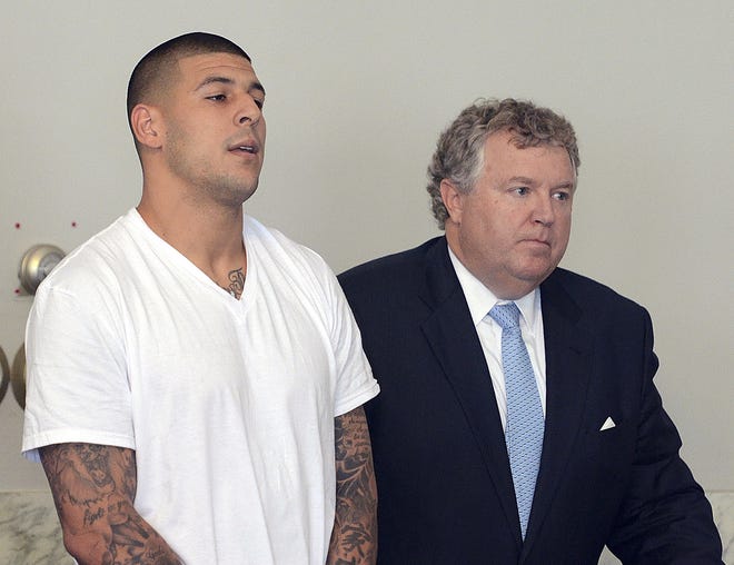 FILE - In this June 26, 2013, file photo, Aaron Hernandez, left, stands with his attorney, Michael Fee, right, during arraignment in Attleboro District Court in Attleboro, Mass. Since Hernandez was arrested last week in the shooting death of a friend whose body was found a mile away from his home, a portrait has emerged of a man whose life away from the field included frequent connections with police-related incidents that started as long ago as his freshman year at the University of Florida. (AP Photo/The Sun Chronicle, Mike George, Pool)