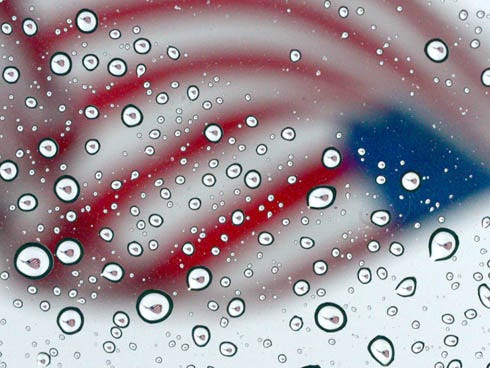 The American flag at Uptown Station in Fort Walton Beach is reflected in rain drops on the Fourth of July. It turned out to be a soggy holiday for locals and thousands of tourists.