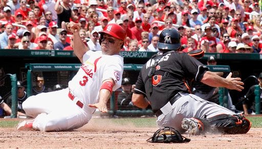 St. Louis Cardinals' Carlos Beltran,left, steals home past Miami Marlins catcher Jeff Mathis, right, in third inning action during a game between the St. Louis Cardinals and the Miami Marlins on Sunday, July 7, 2013, at Busch Stadium in St. Louis. (AP Photo/St. Louis Post-Dispatch, Chris Lee)
