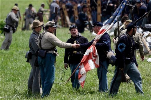 Confederate, left, and Union re-enactors meet after a demonstration of Pickett's Charge during ongoing activities commemorating the 150th anniversary of the Battle of Gettysburg, Sunday, June 30, 2013, at Bushey Farm in Gettysburg, Pa. Union forces turned away a Confederate advance in the pivotal battle of the Civil War fought July 1-3, 1863, which was also the war’s bloodiest conflict with more than 51,000 casualties. (AP Photo/Matt Rourke)