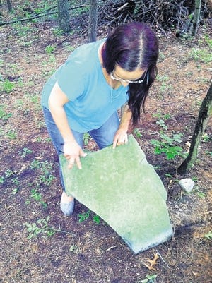 Judy Gumaer Testa, a family historian, turns over a tombstone believed to be that of a black slave of her ancestors, the founders of the Peenpack District settlement now known as parts of Port Jervis and the Town of Deerpark.