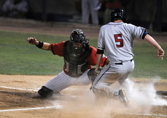 Mavericks catcher Steve Baron, left, tags out the JetHawks' Matt Duffy at home during the fourth inning Monday night in Adelanto.