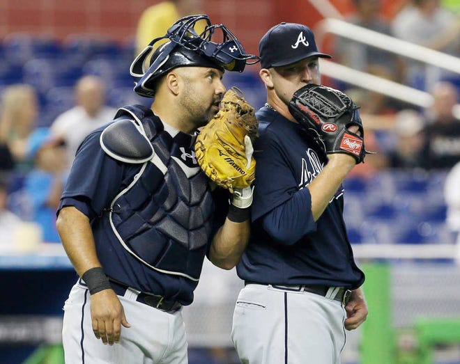 Braves catcher Gerald Laird, left, talks to Paul Maholm after the Marlins' Placido Polanco hit a double driving in Giancarlo Stanton during Atlanta's loss on Wednesday in Miami. (Alan Diaz/AP)