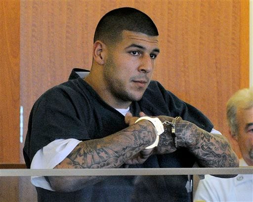 FILE - Former New England Patriots football tight end Aaron Hernandez stands during a bail hearing in Fall River Superior Court in this June 27, 2013 file photo taken in Fall River, Mass. An associate of former New England Patriots tight end Aaron Hernandez said he was told Hernandez fired the shots that resulted in the death of a semi-pro football player, according to documents filed in Florida. The records say Hernandez associate Carlos Ortiz told Massachusetts investigators that another man, Ernest Wallace, said Hernandez shot Lloyd in an industrial park near Hernandez's home in North Attleborough.