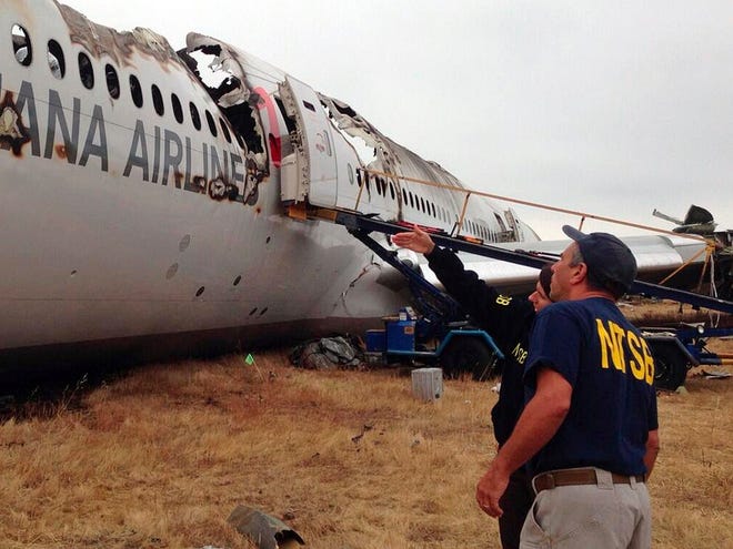 In this photo provided by the National Transportation Safety Board, on Tuesday, July 9, 2013, Investigator in Charge Bill English, foreground, and NTSB Chairwoman Deborah Hersman discuss the progress of the investigation into the crash of Asiana Airlines Flight 214 in San Francisco.