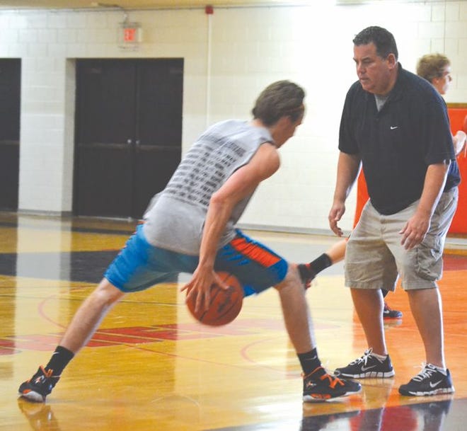 Cheboygan varsity boys' basketball coach Steve Ernst (right) works with Luke Harrington (left) during a dribbling and shooting drill at a Cheboygan basketball camp held at Cheboygan High School on Thursday. The camp, which focused primarily on offensive skills, lasted Monday-Thursday.